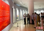 扬州市党外人士书画作品展开幕吸引了不少民众冒雨前来观展，并拍照留念。　崔佳明 摄 - 江苏新闻网