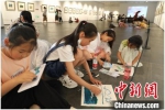 小学生研学活动中在巡展现场席地作画。　 徐州艺术馆供图 - 江苏新闻网