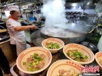 厨师用大锅烹制羊肉汤，迎接众多来店喝羊肉汤的市民。　葛勇 摄 - 江苏新闻网