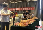 众人围观拍摄获奖的水蜜桃样品。　孙权 摄 - 江苏新闻网