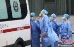 医护工作者向出院人员做出加油鼓劲的手势。　泱波 摄 - 江苏新闻网