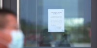 8月6日，在扬州东站，玻璃门上张贴的客运业务临时停办的通告。　孟德龙　摄 - 江苏新闻网