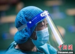 南京当地一位教师穿上防护服，成为一名核酸采样点的志愿者。　泱波 摄 - 江苏新闻网