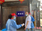 在扬州东关街检测点，志愿者为参加核酸检测的市民测温。　崔佳明 摄 - 江苏新闻网