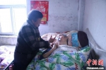 刘俊兰用注射器给丈夫喂水。　颜赛 摄 - 江苏新闻网