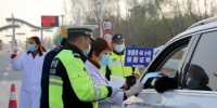 民警在收费站卡口查验过往驾乘人员核酸检测证明和健康码、行程码。　徐州警方供图 - 江苏新闻网
