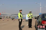民警在徐州观音国际机场对过往车辆进行疫情防控检查并做好疏导和秩序维护工作。　徐州警方供图 - 江苏新闻网