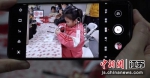 两岸家庭家长拍摄孩子画年画。张传明 摄 - 江苏新闻网