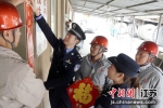 民警在给就地过年的矿厂工人一起贴春联。南京铁路公安处镇江站派出所供图 - 江苏新闻网
