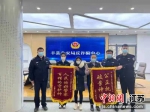 李女士送上两面锦旗感谢警方及时帮助追回被骗的9万元。张森 摄 - 江苏新闻网