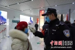 民警在为进站旅客测量体温。南京铁路公安处镇江站派出所供图 - 江苏新闻网