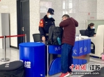 民警在为进站旅客测量体温。南京铁路公安处镇江站派出所供图 - 江苏新闻网