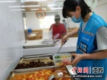 工作人员为老人打好饭菜。无锡市民政局供图 - 江苏新闻网