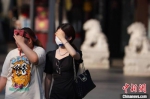 南京迎来高温天气，阳光热辣刺眼，市民在热浪中出行。　泱波 摄 - 江苏新闻网