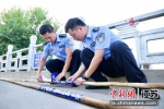 民警在竹竿上张贴警示标志 - 江苏新闻网