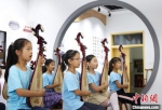 苏州新区枫桥实验小学的学生在老师的指导下弹奏苏州评弹。　泱波 摄 - 江苏新闻网
