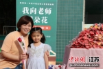 老师拿着花和孩子拍照。陈耶莉 摄 - 江苏新闻网