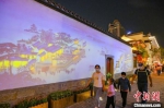 古建筑墙壁上投影出《南都繁会景物图卷》。　泱波 摄 - 江苏新闻网