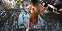 市民在积水的道路上经过。　泱波 摄 - 江苏新闻网