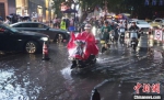 暴雨导致部分道路积水，市民骑车从水中驶过。　泱波 摄 - 江苏新闻网